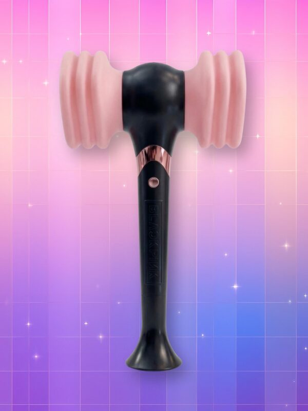 Un lightstick Blackpink version 1 sous la forme comme d'un marteau au corps noir et aux bouts latéraux roses avec effet accordéon, sur un fond artificiel coloré avec un gradient allant du rose au violet.