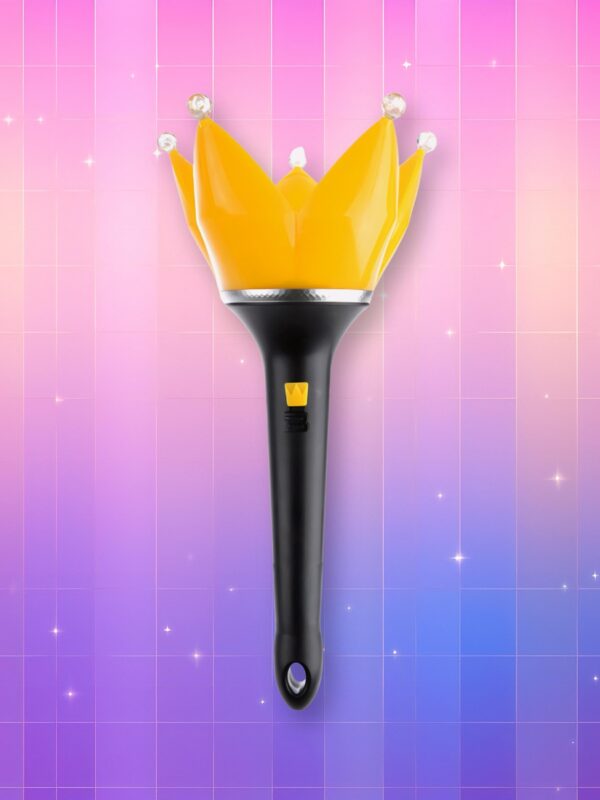 Un bigbang lightstick version 4 à manche noir avec un bulbe en forme de couronne à 5 branches jaunes et à bout rond et blanc, sur un fond artificiel coloré avec un gradient allant du rose au violet.
