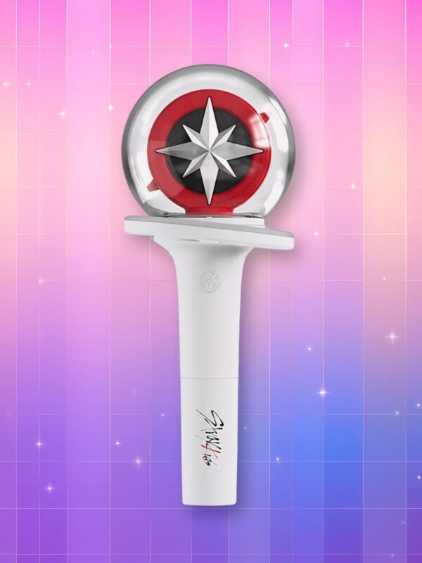 Un lightstick Stray Kids version 2 présentant un manche blanc et un bulbe translucide contenant un cercle rouge et noir avec une rosace des vents blanche en son centre, sur un fond artificiel coloré avec un gradient allant du rose au violet.