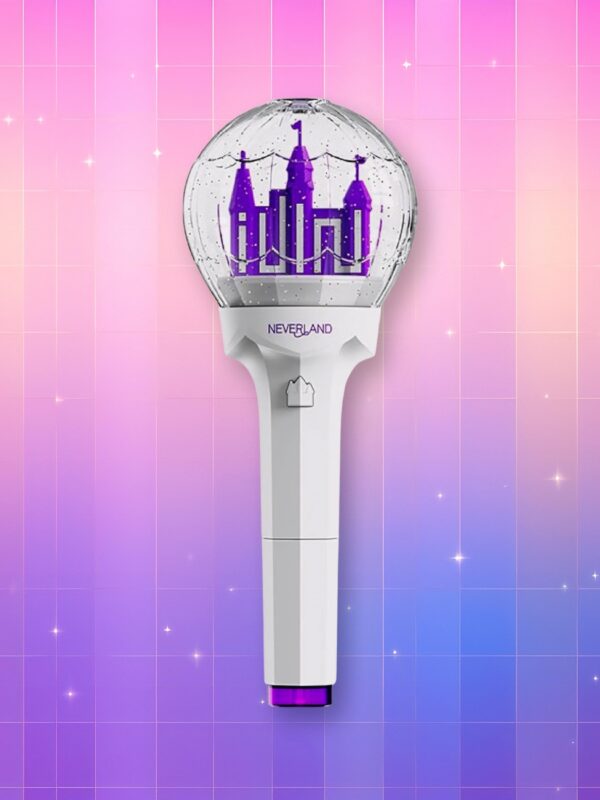 Un Gidle lightstick version 2 présentant un manche blanc, une bague violette et un dome translucide laissant apparaître leur logo ressemblant à un chateau violet, sur un fond artificiel coloré avec un gradient allant du rose au violet.