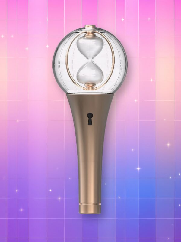Un lightstick Ateez Lightiny version 2 composé d'un manche couleur or, d'un trou de serrure et d'un bulbe transparent contenant un sablier, sur un fond artificiel coloré avec un gradient allant du rose au violet.