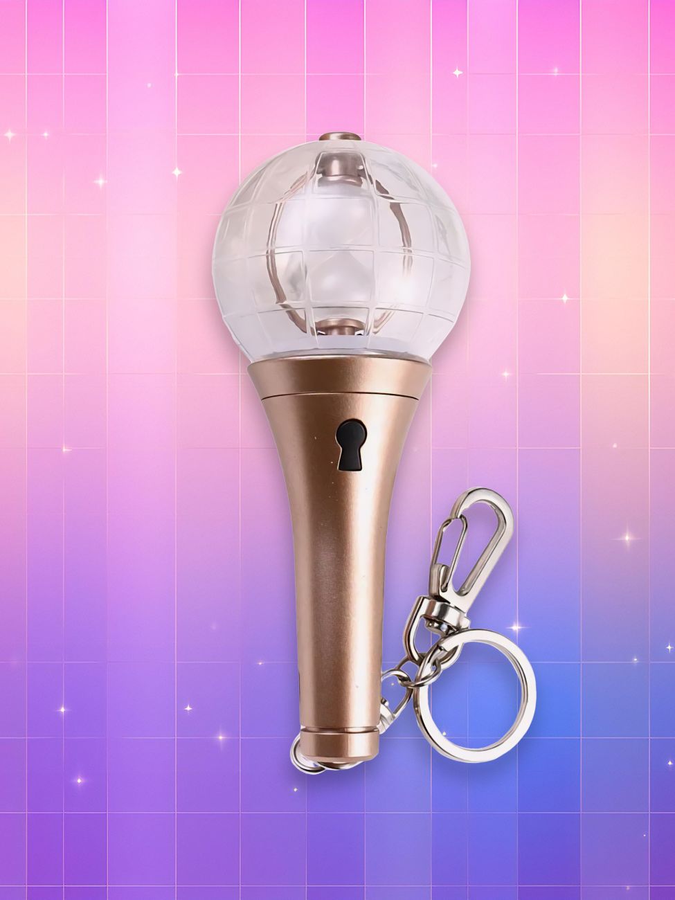 Un lightstick Ateez Lightiny version porte-clés, composé d'un manche couleur or, d'un trou de serrure et d'un bulbe transparent contenant un sablier, sur un fond artificiel coloré avec un gradient allant du rose au violet.
