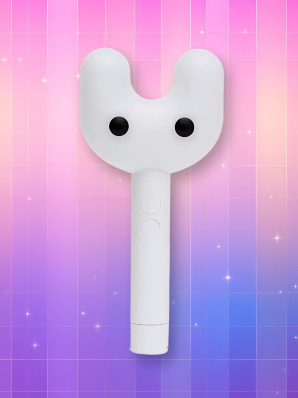Un lightstick New Jeans Binky Bong entièrement blanc représentant un manche droit dont la tête se sépare en deux branches formant une tête de lapin avec deux billes noires en guise de yeux, sur un fond artificiel coloré avec un gradient allant du rose au violet.