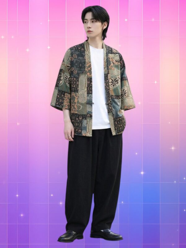 Un homme asiatique porte une veste kimono homme patchwork et motifs traditionnels aux tons verts et beiges, sur t-shirt blanc et pantalon large noir, fond rose-violet dégradé.