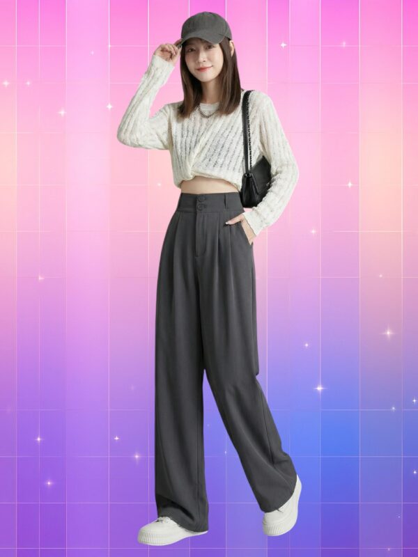 Femme asiatique portant un pantalon taille haute coréen au tombé fluide, gris anthracite, avec crop top en maille et casquette, posant sur fond rose-violet lumineux.