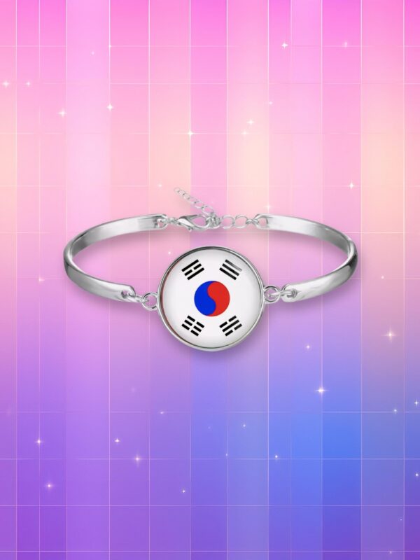 Un bijou coréen bracelet drapeau de la Corée du Sud en argent avec un médaillon rond sur un fond coloré scintillant.