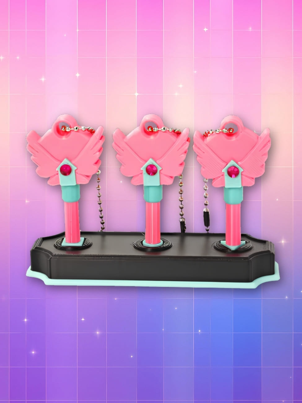 Jeu coréen des 3 clés dans Squid Game. Composé d'un support noir où sont plantées les trois clés roses. Sur fond dégradé de rose à violet.