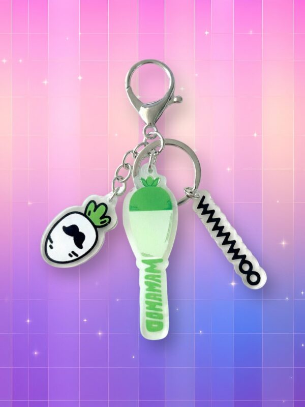 Un porte-clés kpop Mamamoo en acrylique représentant le lighstick du groupe et leur logo sur un fond composé d'un dégradé rose violet.