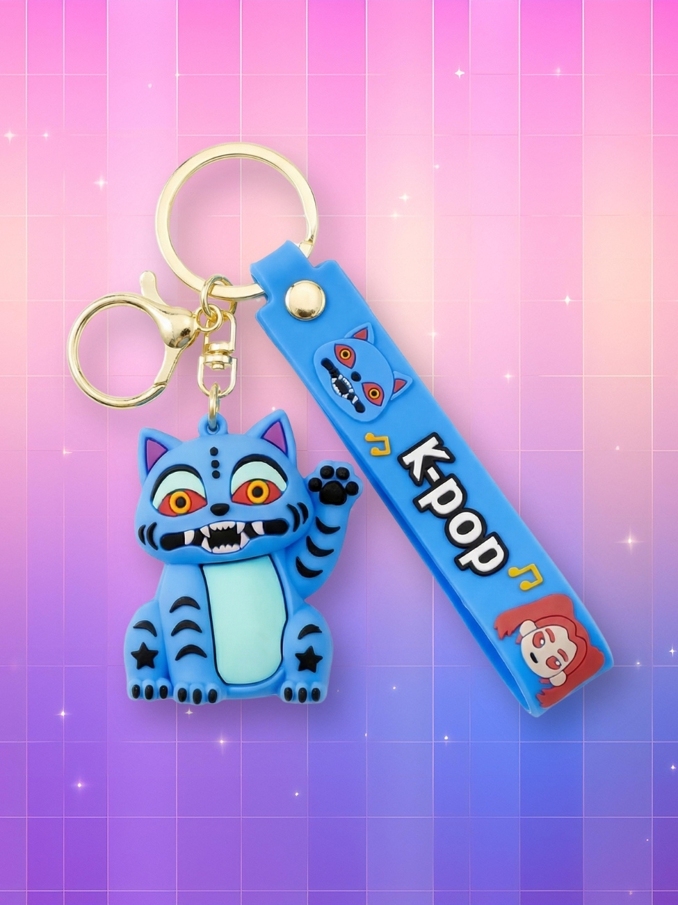Un porte-clés kawaii Kpop Demon Hunters Derpy le tigre bleu avec un mousqueton doré et une sangle bleue avec écrit "kpop" dessus, sur un fond artificiel coloré avec un gradient allant du rose au violet.