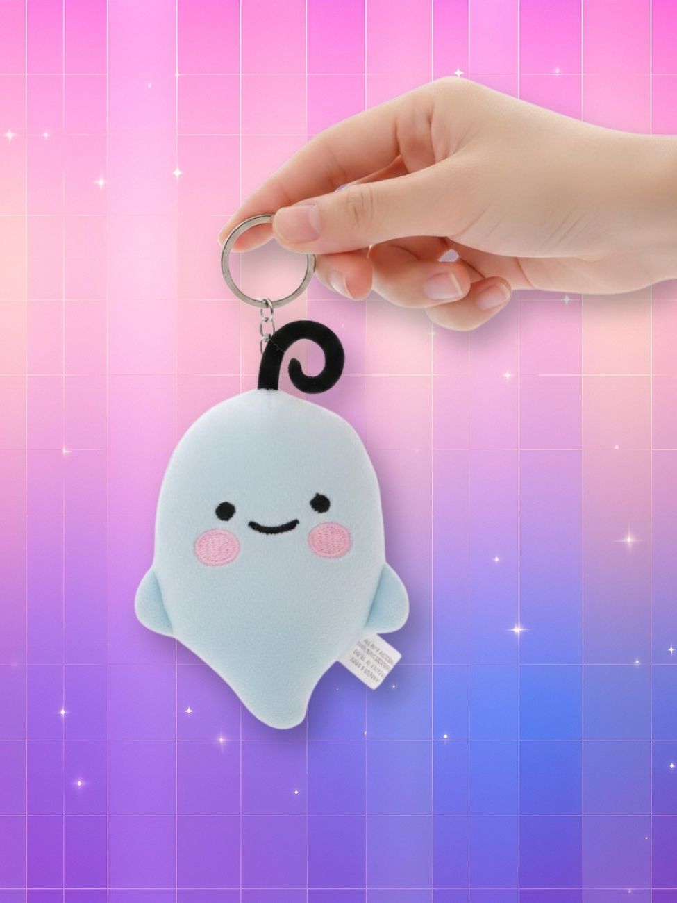 Peluche porte-clés Le Sserafim - Heurimong sur fond multicolore violet et rose et porté par une main