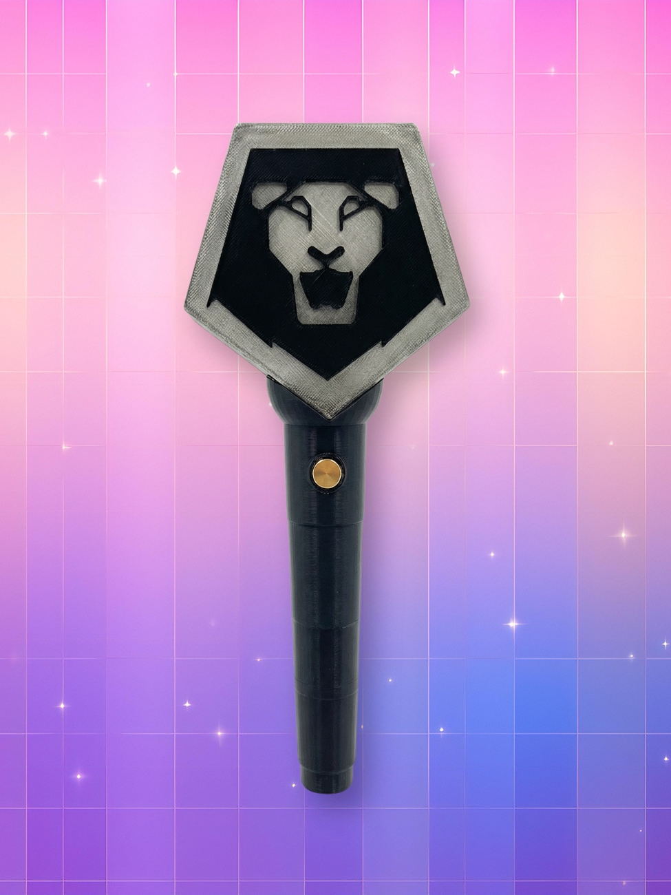 Un lightstick lumineux Kpop Demon Hunters Saja Boys avec un manche noir et une tête grise en forme de pentagone illustrant une tête de lion, présenté sur un fond dégradé de rose et de violet parsemé de petites étoiles étincelantes.
