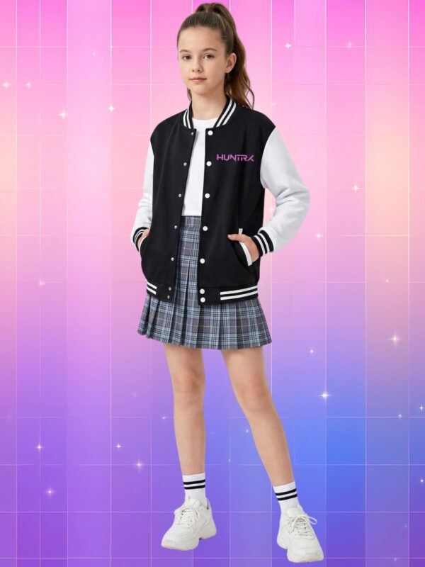 Une jeune fille portant un blouson bomber Kpop Demon Hunters Huntrix noir et blanc sur une jupe plissée, devant un fond quadrillé de couleur rose et violet.
