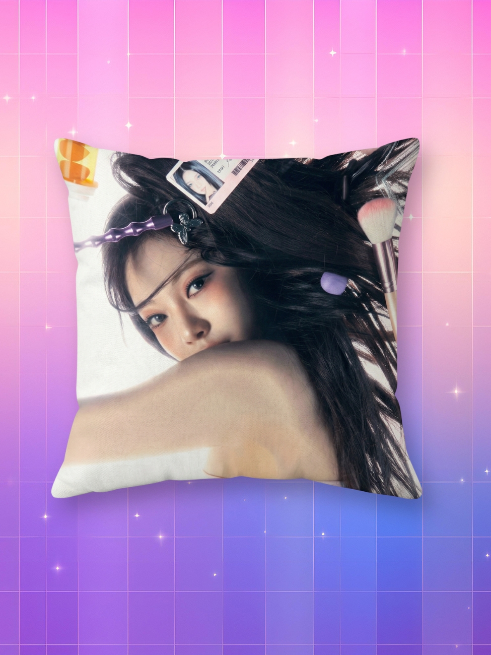 Une taie d’oreiller kpop Ningning montrant le visage de la chanteuse aux longs cheveux noirs parsemés d'accessoires de maquillage, posée sur un fond dégradé rose et bleu avec des petits éclats brillants.