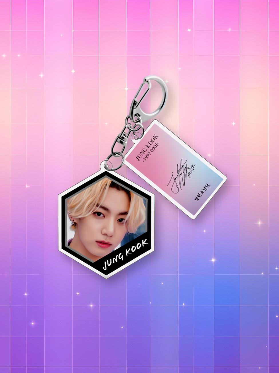 Un porte-clé kpop BTS coloré montrant une photo de Jungkook dans un cadre hexagonal et un pendentif rectangulaire pastel, sur un fond dégradé rose et bleu avec des étoiles.