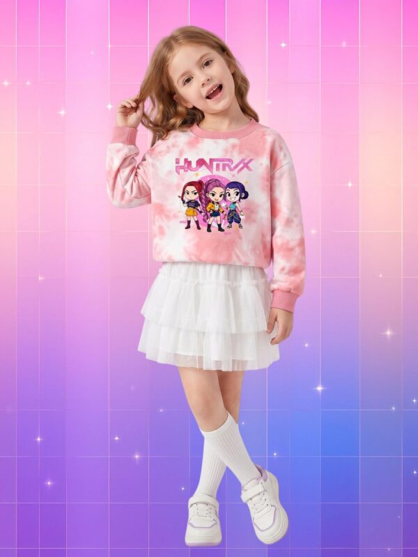 Une petite fille portant un pull Kpop Demon Hunters enfant Huntrix rose et blanc avec une jupe blanche sur un fond rose et violet.
