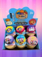 Une boîte ouverte présente plusieurs jouets colorés Jouet squishy Kpop Demon Hunters en blind box surprise, décorés de personnages, sur un fond rose et violet.