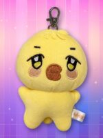 Une peluche jaune en forme de petit personnage, appelée peluche porte-clés bbyongMING ANITEEZ, avec un mousqueton métallique, sur un fond rose et violet scintillant.