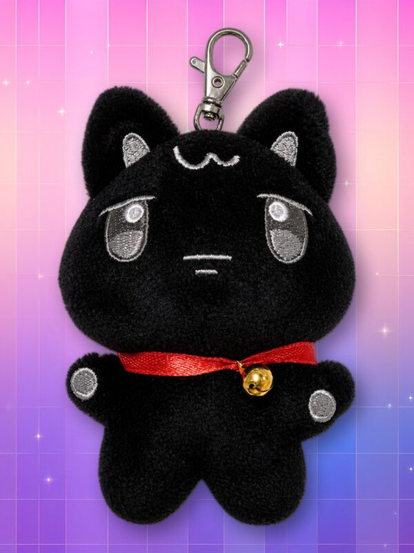 Une peluche porte-clés WOOYOnyang ANITEEZ noire en forme de chat, avec un nœud rouge et une clochette dorée, sur un fond quadrillé rose et violet.